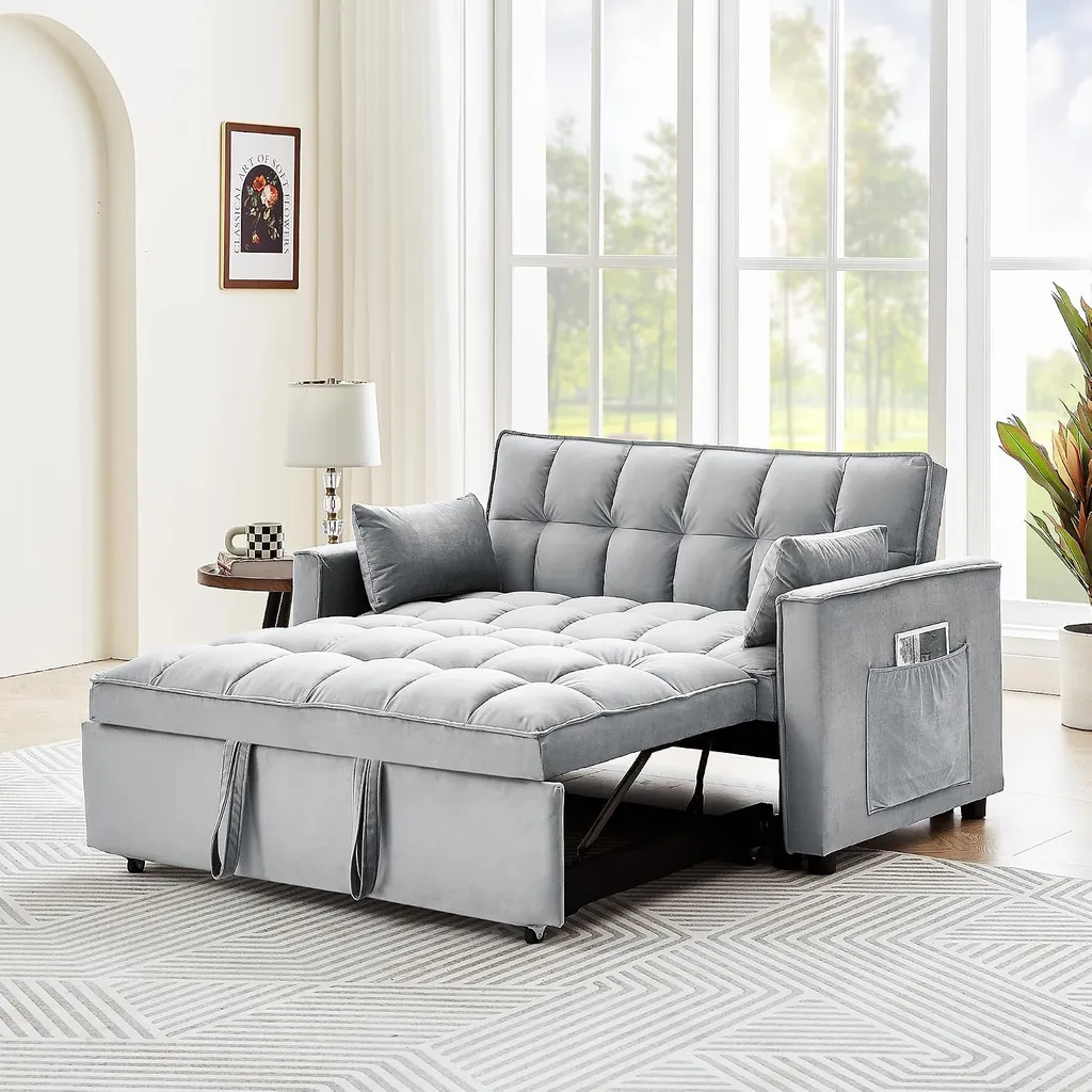 A gray sofa bed with pillows, a lamp, and a potted plant in a room.