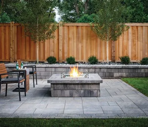 A backyard with a fire pit, chairs, and a wooden fence.