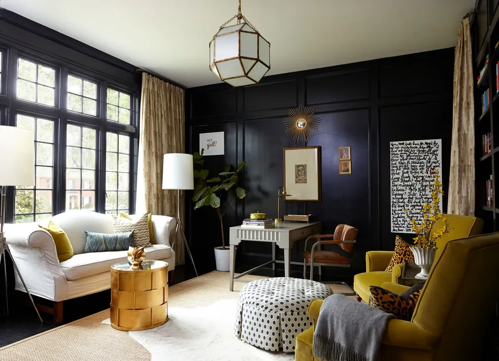 A living room with black walls, a white couch, a desk, and a yellow chair.